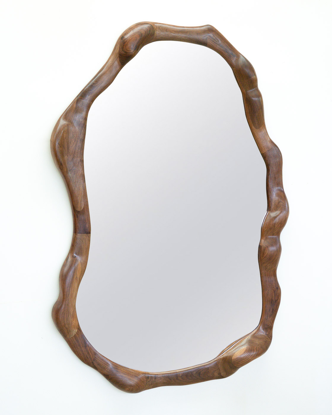 sculptural mirror in natural walnut