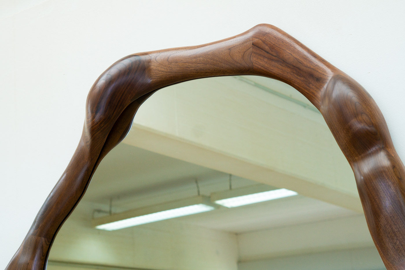 sculptural mirror in natural walnut