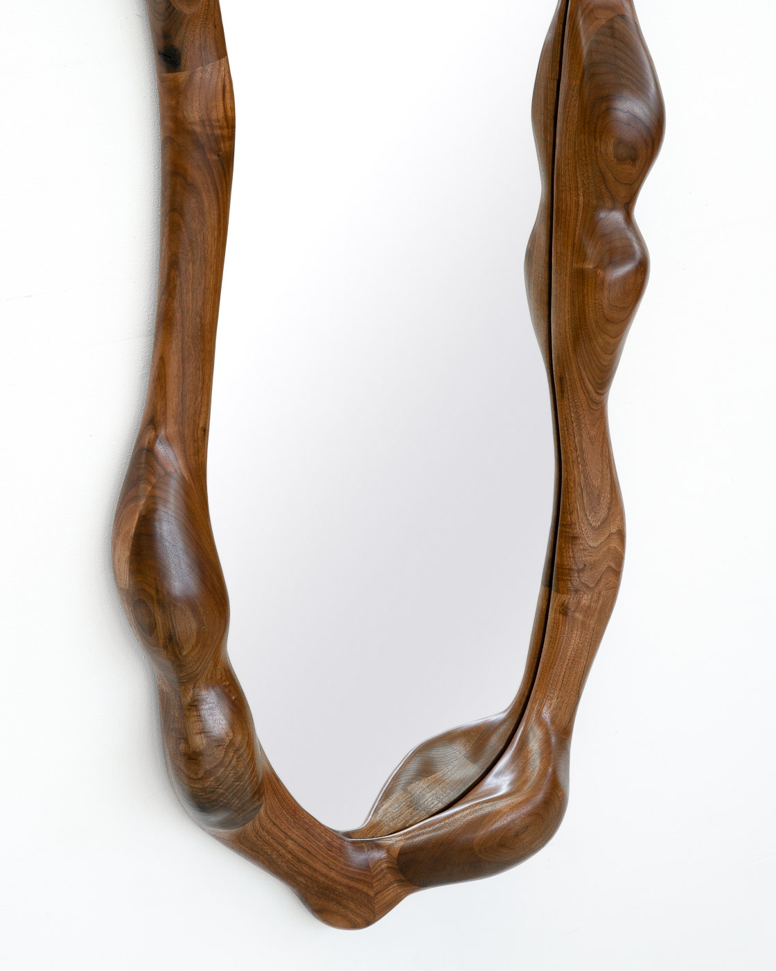 sculptural mirror in natural walnut
