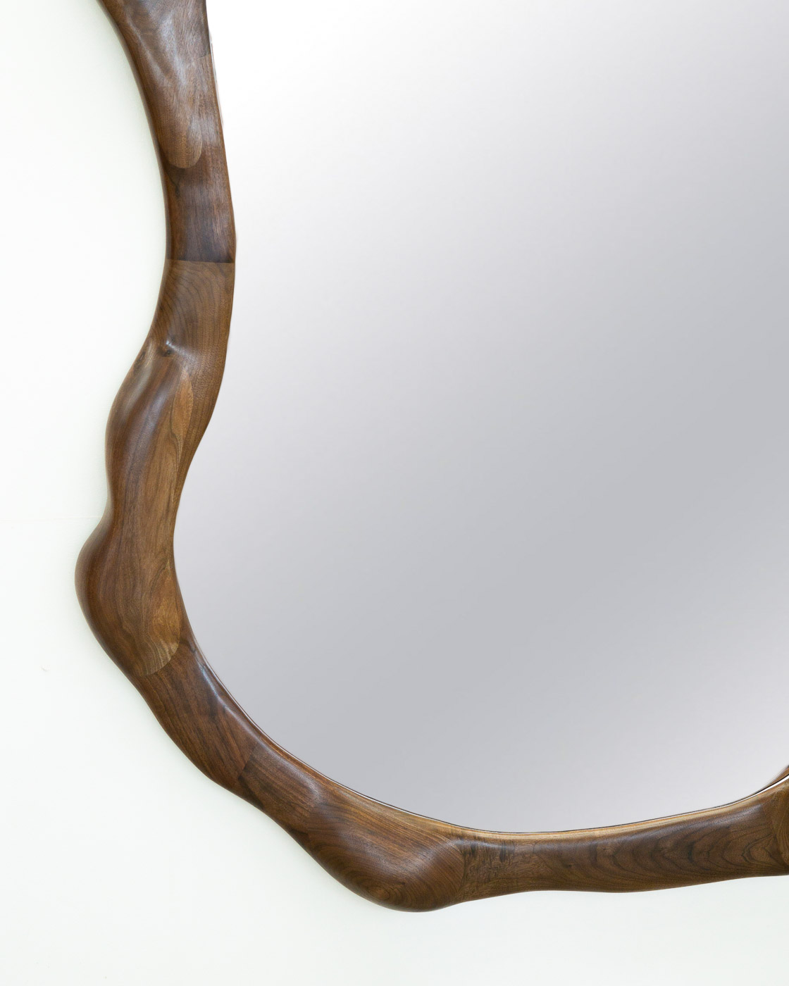 sculptural mirror in natural walnut