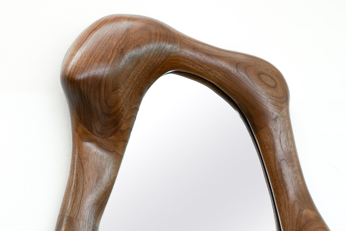 sculptural mirror in natural walnut