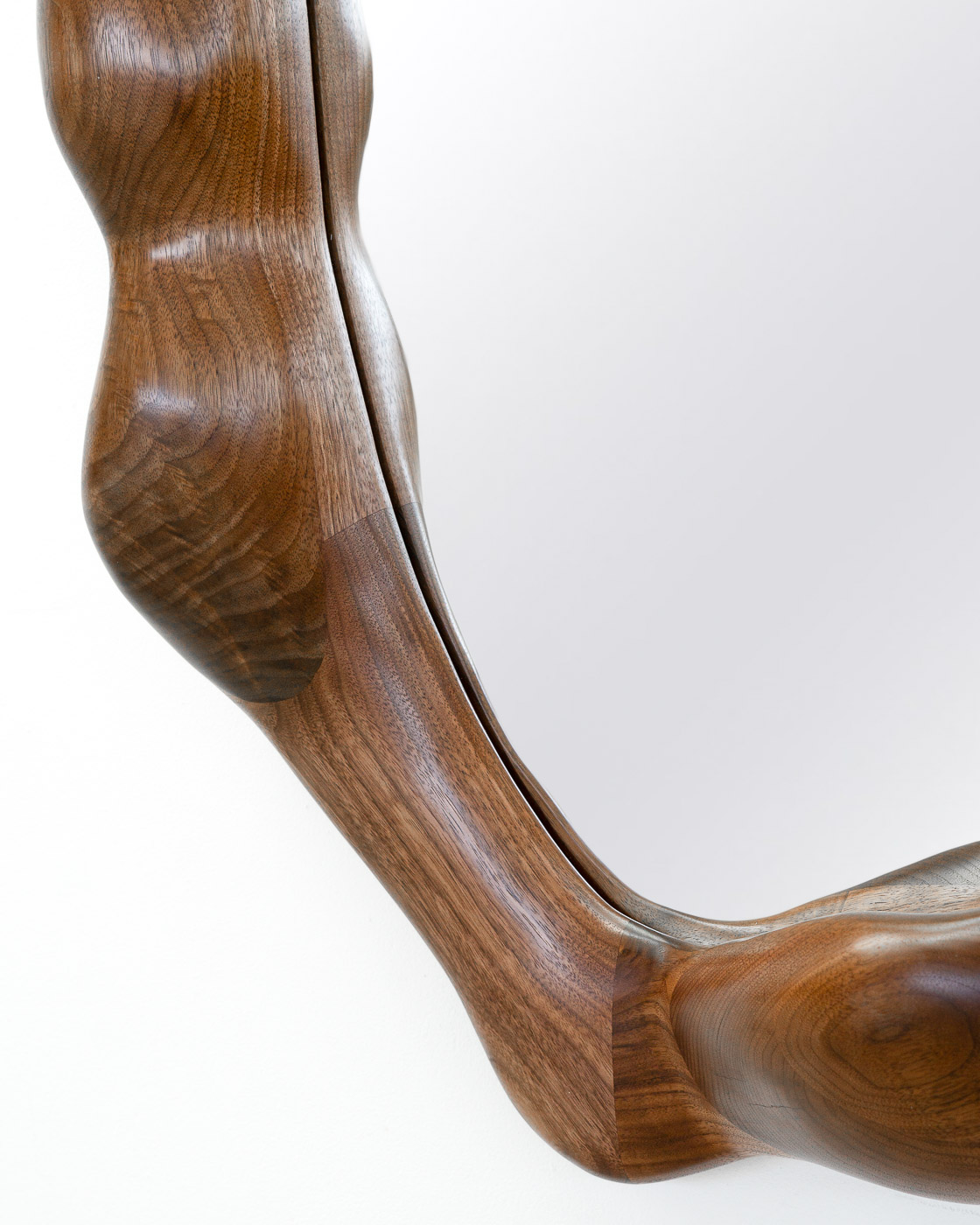 sculptural mirror in natural walnut