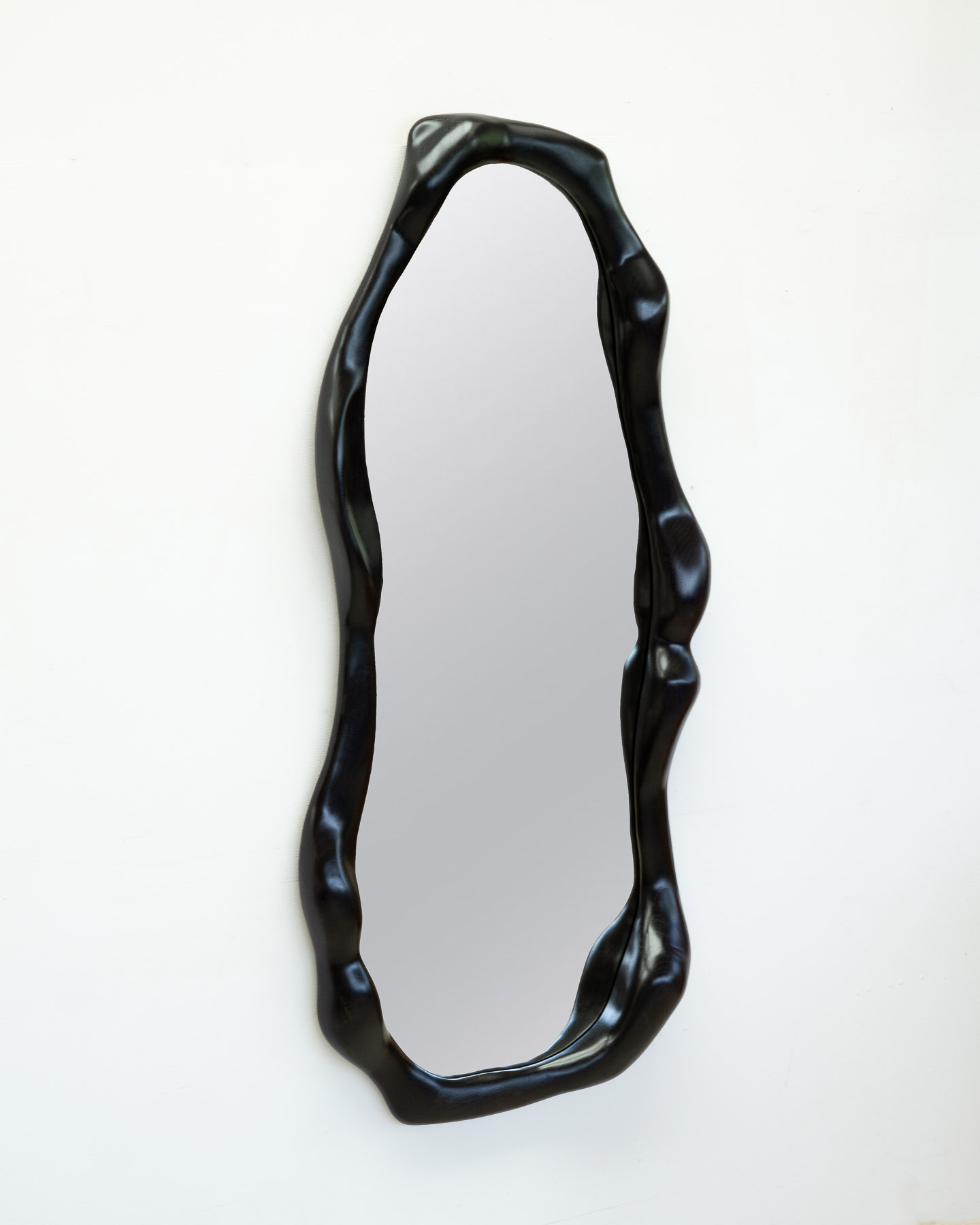 sculptural mirror in ebonized walnut