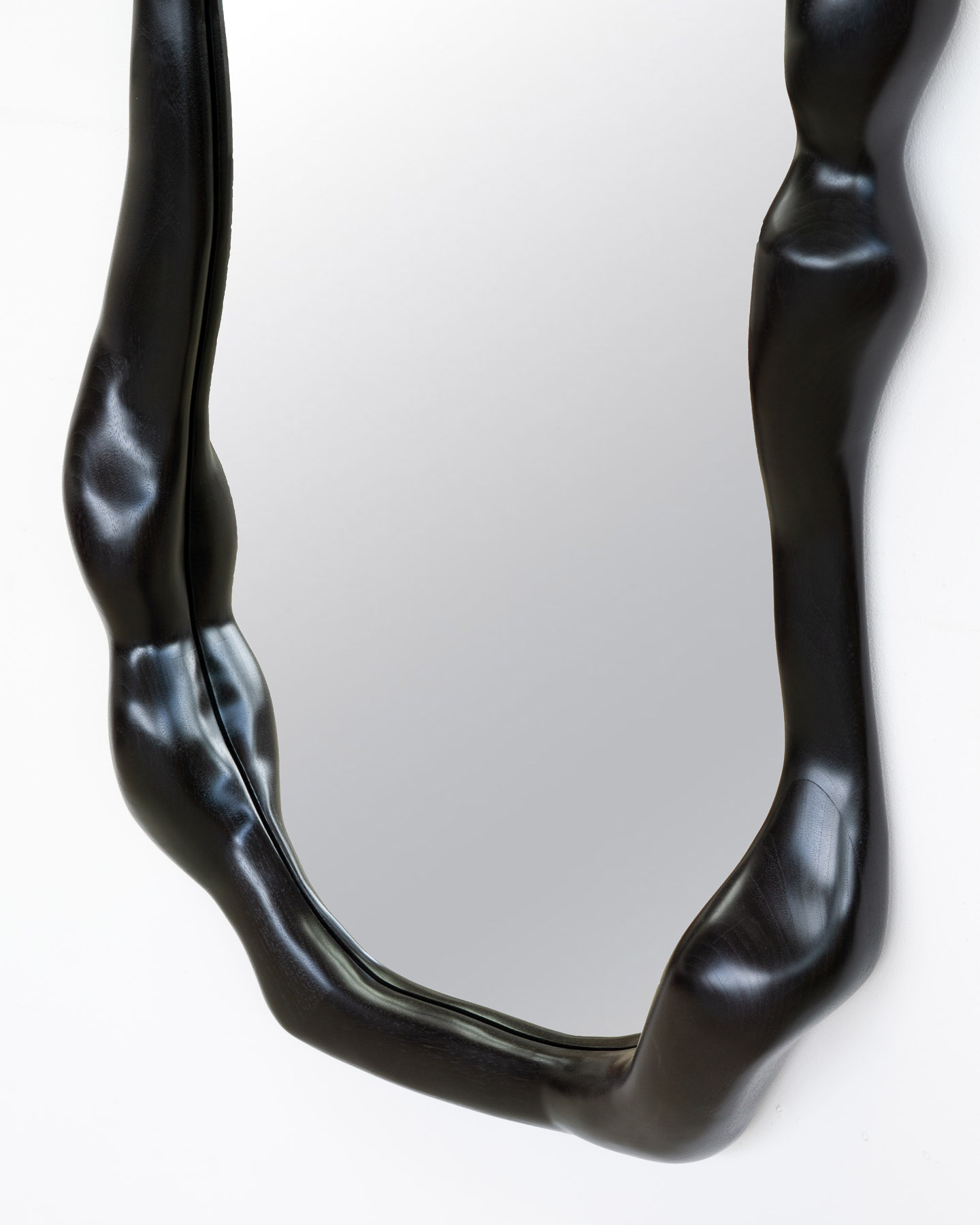 sculptural mirror in ebonized walnut