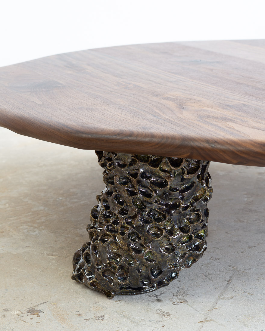 coffee table in walnut with three sculptural legs made of dark green ceramic